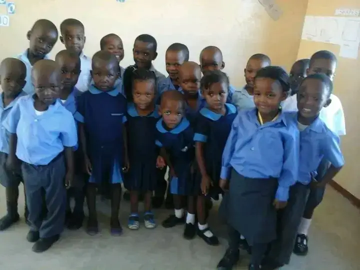 Young learners in school uniform smiling for a class photo