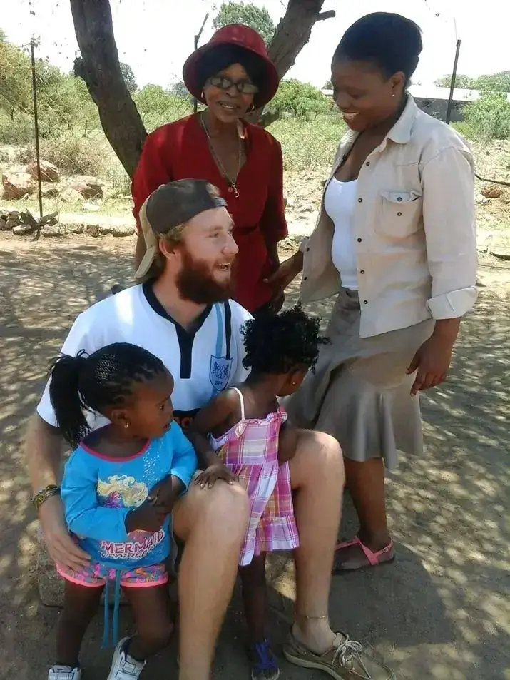 Volunteer and community members with two young girls
